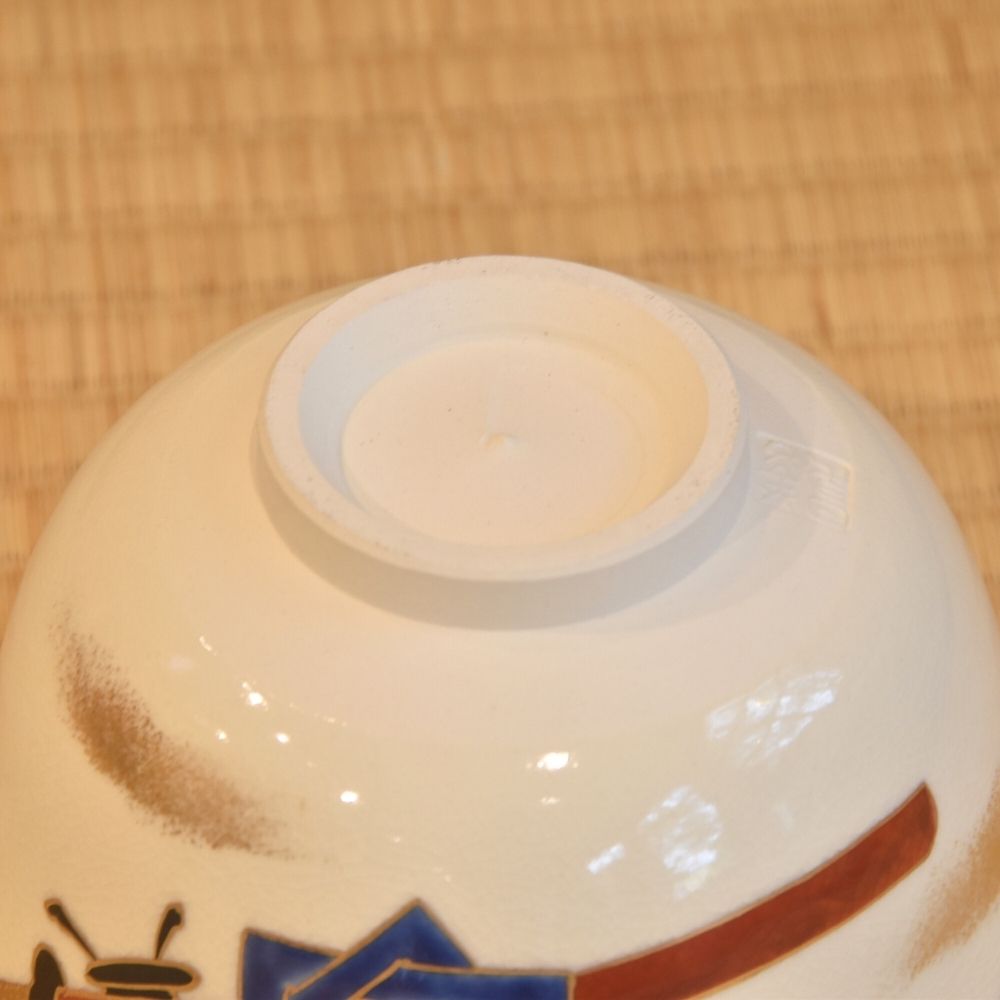 Close-up of the underside and foot of the Zensho Yamaoka matcha bowl with part of the painted brown and blue exterior visible.