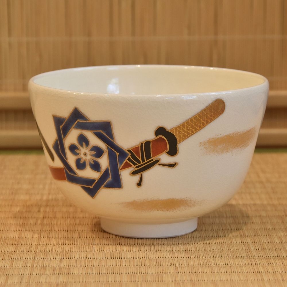 Left-side view of the Ryoma Sakamoto matcha bowl showing a black pistol, blue crest, and warm brown painted accents.