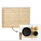 A wooden rectangular tray with printed circular and linear guides, shown alongside an inset usage photo of black bowls and a small decorative item placed on the tray. Japanese text appears above and below, explaining the guide design and usage.