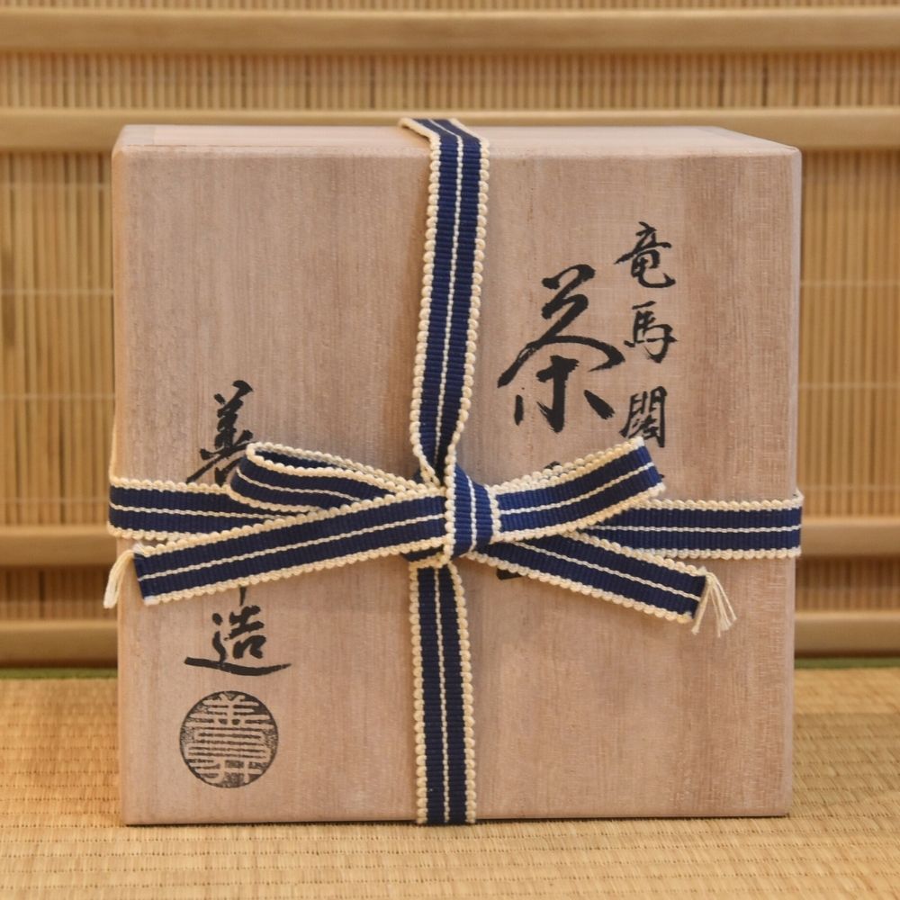 Gift box with a blue ribbon on a traditional Japanese tatami mat background