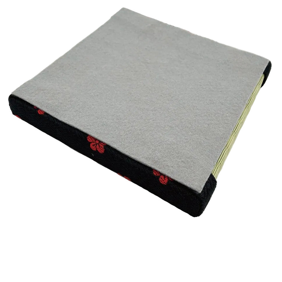 Gray fabric mat with black border and red patterns on a white background