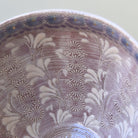 Close-up of a ceramic bowl with floral patterns on a light background