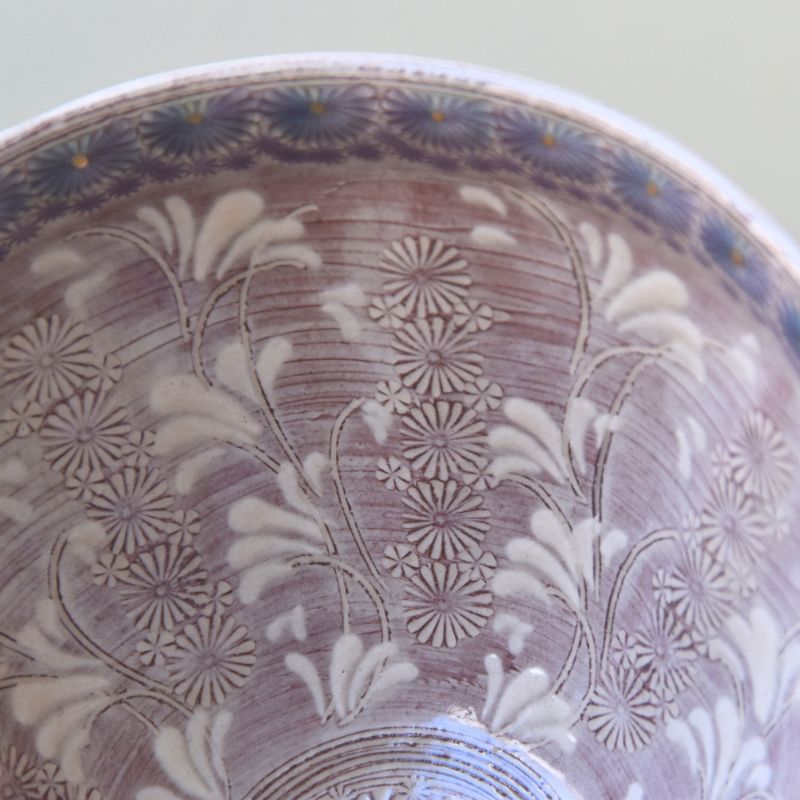Close-up of a ceramic bowl with floral patterns on a light background