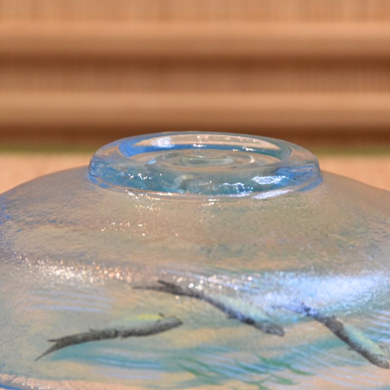 Close-up of a ceramic plate with a scenic design on a wooden surface