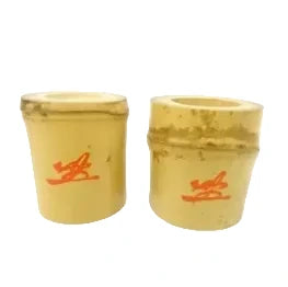 Two yellow cups with red designs on a white background