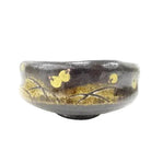 Ceramic bowl with gold leaf design on a white background
