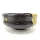 Black ceramic bowl with gold accent on a white background