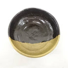 Black and gold ceramic dish on a white background