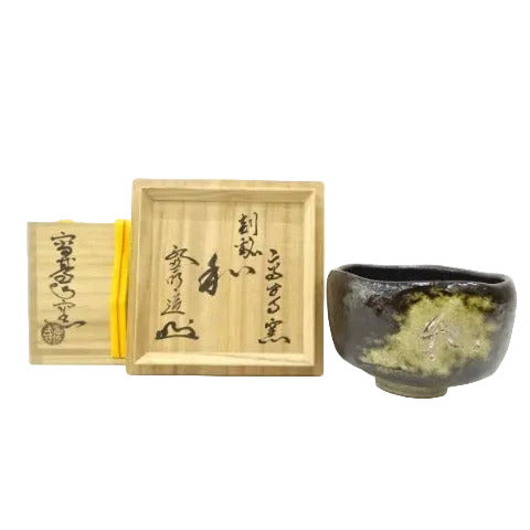 Black ceramic cup with wooden box featuring Japanese calligraphy on a white background