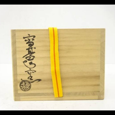 Wooden box with a yellow ribbon on a white background