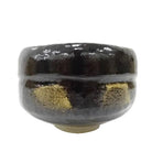 Black ceramic bowl with gold accents on a white background