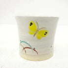 Ceramic cup with butterfly design on a white background