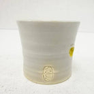 White ceramic cup with a logo on a white background