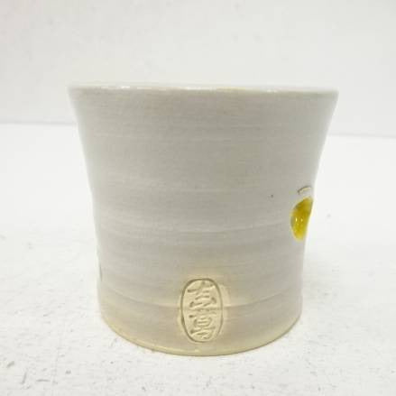 White ceramic cup with a logo on a white background