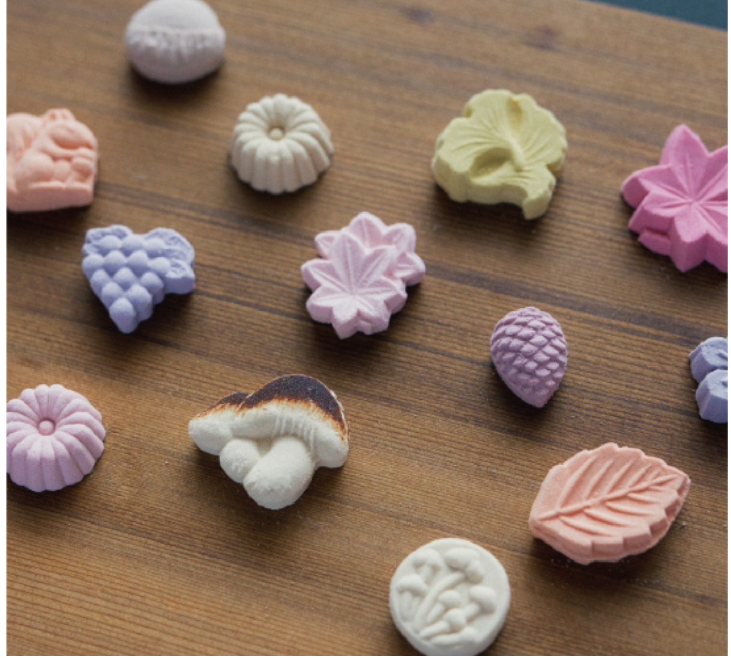 Assorted colorful candy pieces on a wooden surface