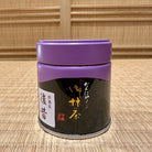 Black cylindrical container with purple lid on a woven mat background