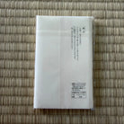 White paper or card with text on a woven mat background