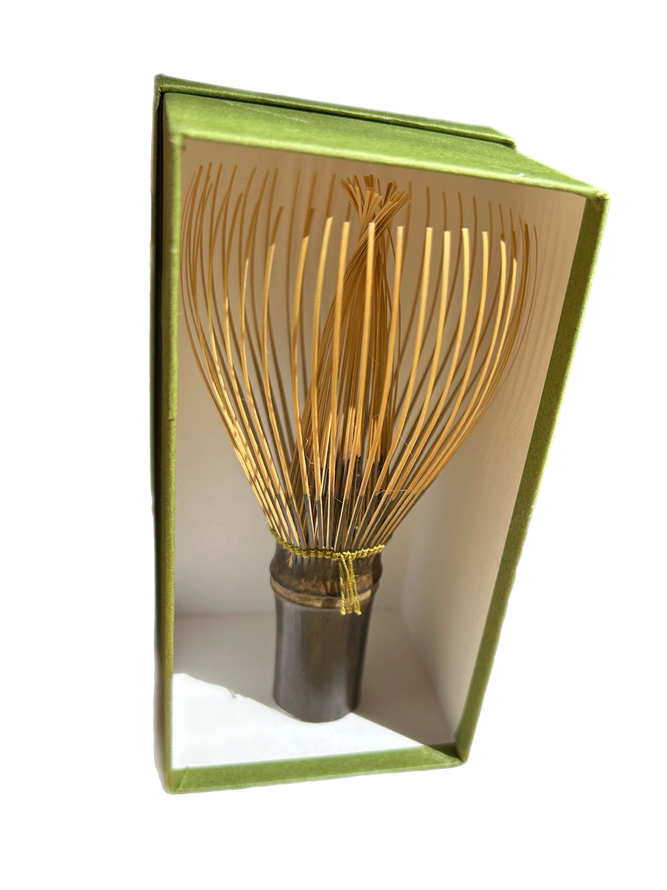 Tea whisk with wooden handle and bamboo bristles in an open book