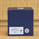 Blue box with white label on a bamboo mat background