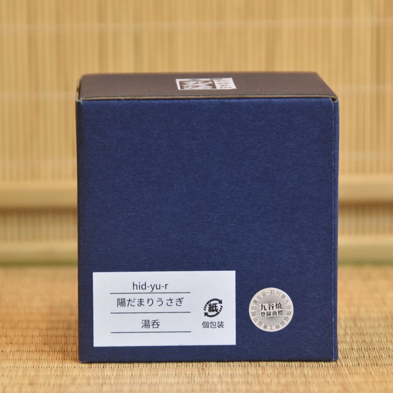Blue box with white label on a bamboo mat background