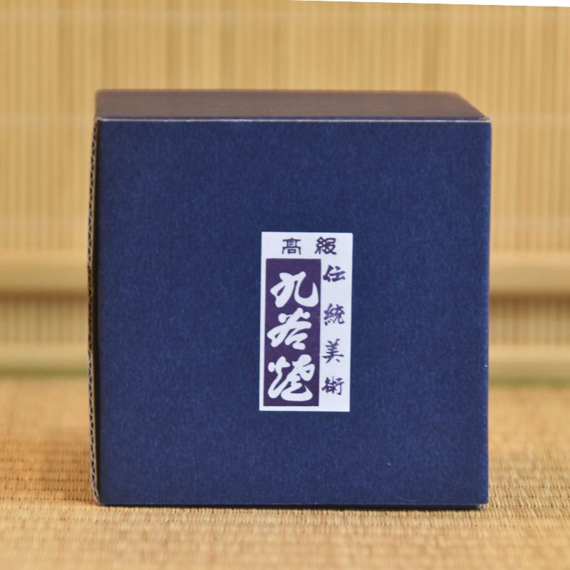 Blue box with a white label on a bamboo background