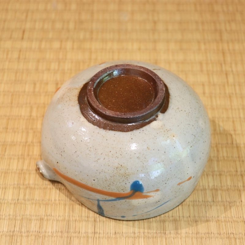 Ceramic container with a brown lid on a woven mat
