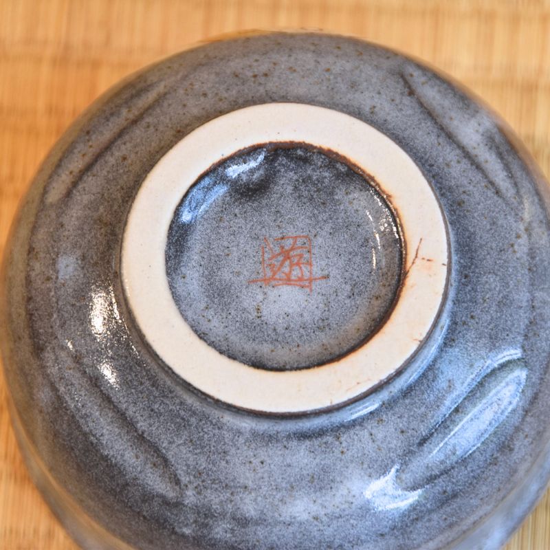 Close-up of a ceramic bowl with a textured surface on a wooden background