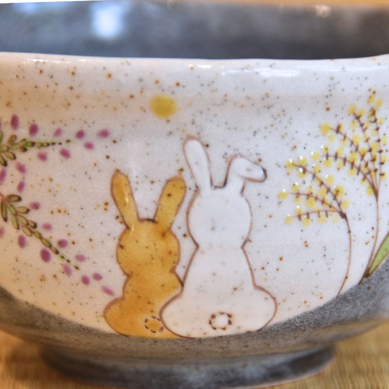 Ceramic bowl with rabbit design on a wooden surface