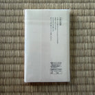 White paper or card with text on a woven mat background