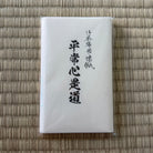 White rectangular product with black text on a woven mat background