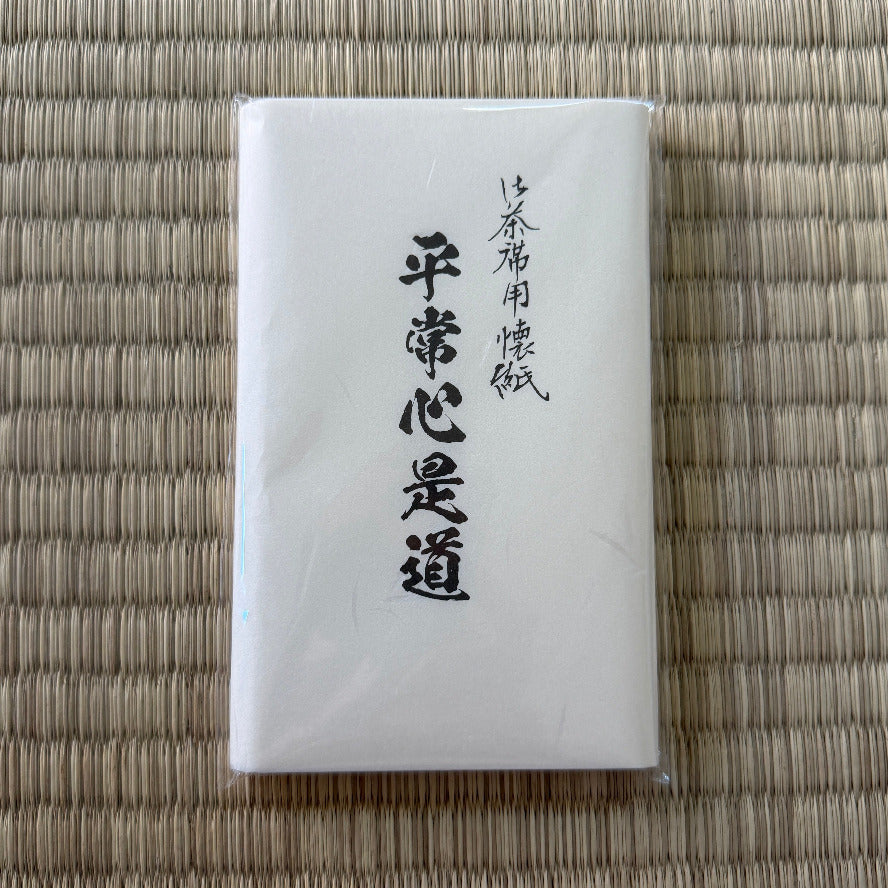 White rectangular product with black text on a woven mat background