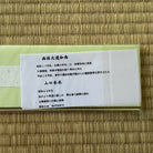 White card with Japanese text on a woven mat background