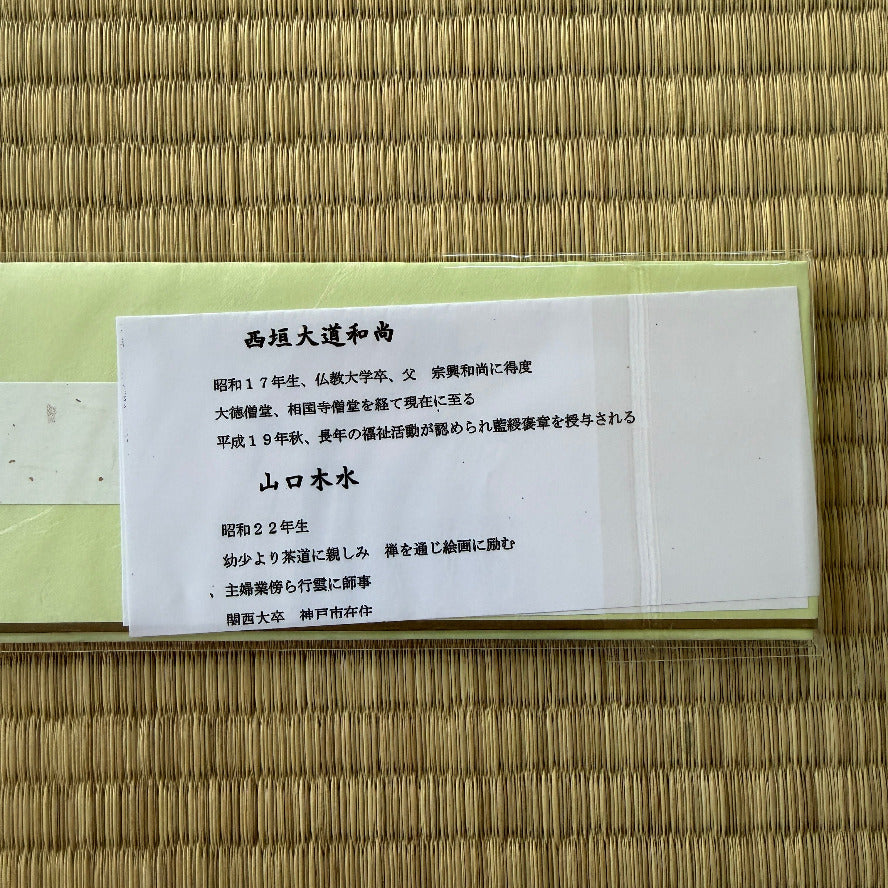 White card with Japanese text on a woven mat background