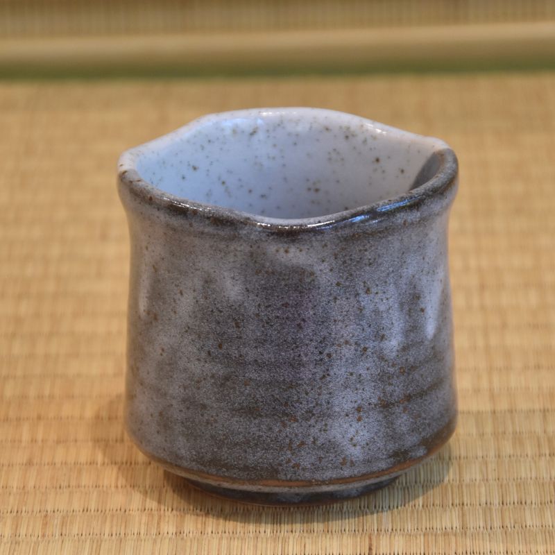 Ceramic cup with a textured surface on a bamboo mat background