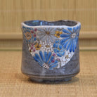 Ceramic cup with floral patterns on a woven mat background