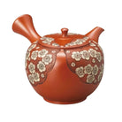 Ceramic teapot with floral patterns on a white background