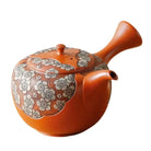 Ceramic teapot with floral patterns on a white background