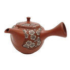 Ceramic teapot with floral pattern on a white background