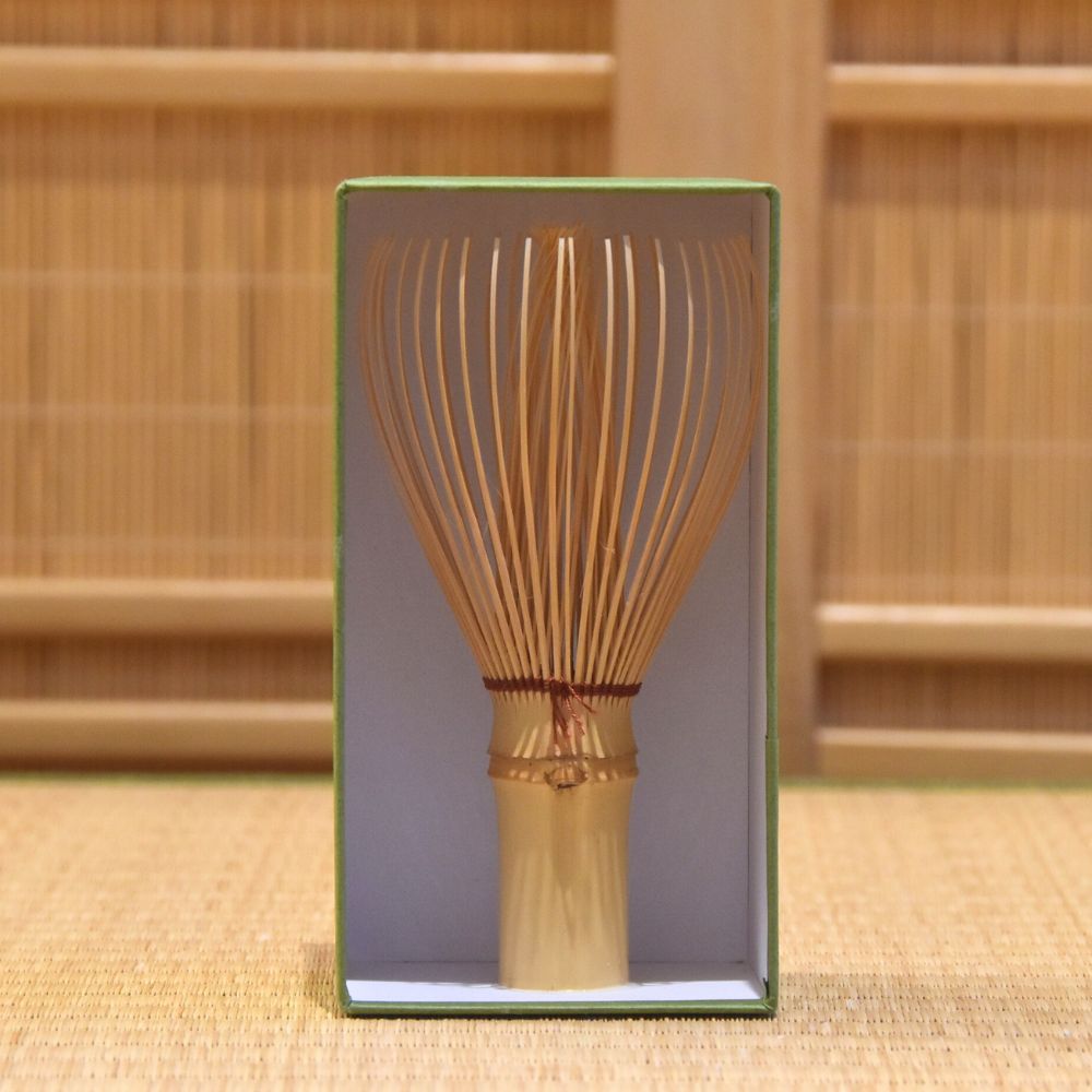 Bamboo whisk in a box with a wooden background
