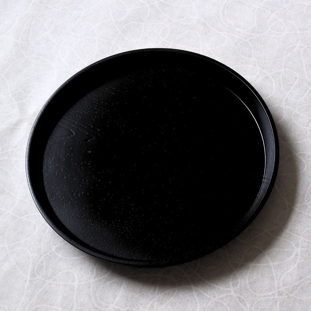 Two black lacquered tray on a textured white surface