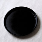 Two black lacquered tray on a textured white surface