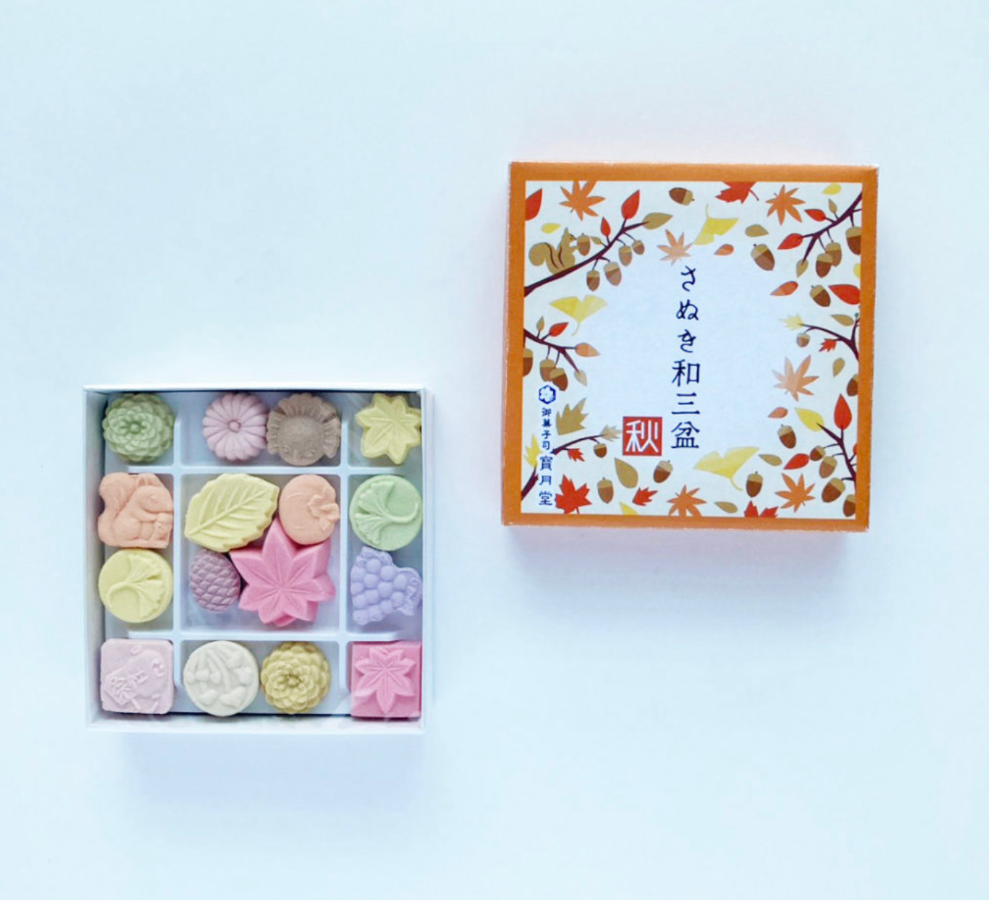 Box of colorful higashi with a decorative lid on a light gray background