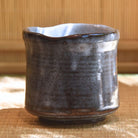 Ceramic cup with a textured surface on a woven mat