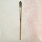 Long, thin metal object on a textured white background