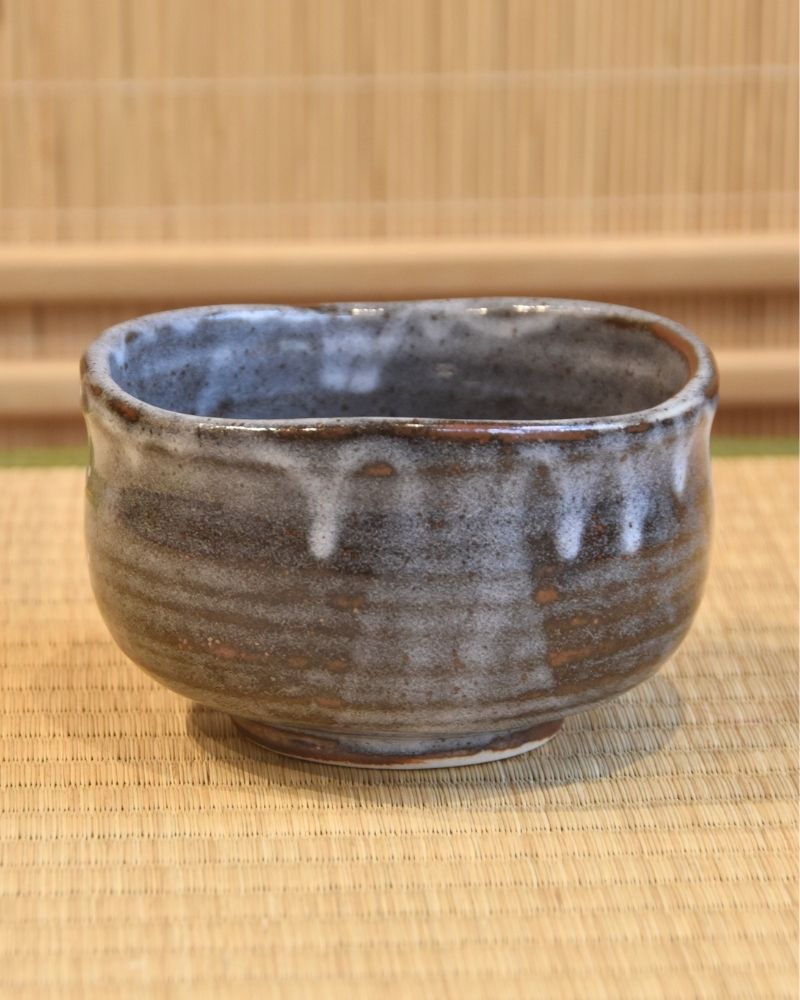 A matcha bowl with gray glaze dripping down.