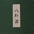 Rectangular white label with black text on a textured green background