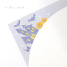 Halloween-themed fabric with pumpkins, bats, and a haunted house on a light purple background.