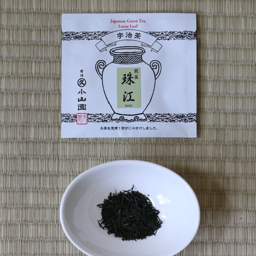 Tea packaging with a bowl of black tea leaves on a woven mat