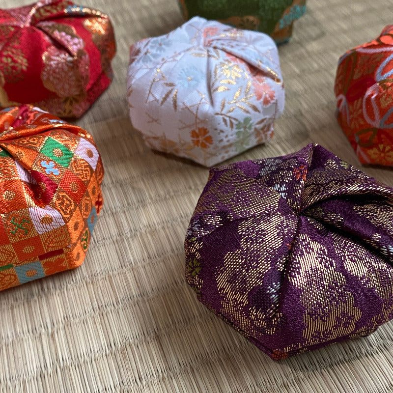 Colorful fabric wrapped packages on a textured surface