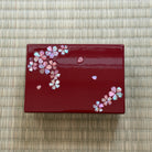 Red decorative item with floral patterns on a woven mat